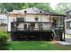 Charming home featuring a spacious deck, complemented by a lush green lawn and mature trees at 728 Antone Nw St, Atlanta, GA 30318