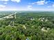 Lush green neighborhood from above, featuring homes nestled among trees and a distant road at 1340 Gran Forest Dr, Cumming, GA 30041