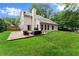 Back of home with stone patio, outdoor furniture and lush green lawn at 1340 Gran Forest Dr, Cumming, GA 30041