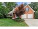 Charming two-story brick home with a well-manicured lawn, two-car garage, and blue shutters at 1340 Gran Forest Dr, Cumming, GA 30041
