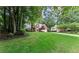 A beautiful exterior view of a brick home with a lush green lawn and mature trees in a serene neighborhood at 1340 Gran Forest Dr, Cumming, GA 30041