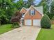 Home exterior with a two-car garage, brick facade, and landscaped front yard at 1340 Gran Forest Dr, Cumming, GA 30041