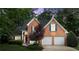 Two-story brick home featuring blue shutters, a front lawn, and a two-car garage at 1340 Gran Forest Dr, Cumming, GA 30041