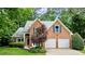 Two-story brick home with blue shutters, two car garage and manicured front lawn at 1340 Gran Forest Dr, Cumming, GA 30041