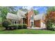 Charming two-story brick home featuring a well-manicured lawn, lush shrubbery, and an attached two-car garage at 1340 Gran Forest Dr, Cumming, GA 30041