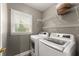 Laundry room features a washer and dryer, wire shelving, window and neutral color scheme at 1340 Gran Forest Dr, Cumming, GA 30041
