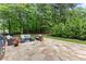 Stone patio with seating surrounded by mature trees at 1340 Gran Forest Dr, Cumming, GA 30041