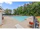Relaxing community pool area with lounge chairs, umbrellas and mature trees in the background at 1340 Gran Forest Dr, Cumming, GA 30041