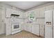 Well-equipped kitchen with white cabinets and appliances, providing a functional cooking space at 1960 Oak Leaf Sw Ct, Marietta, GA 30008