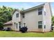 View of the backyard with lawn and vinyl sided two-story home featuring multiple windows for plenty of natural light at 4424 English Loop, Stonecrest, GA 30038