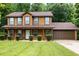 Charming two-story home featuring a well-maintained lawn, mature trees, and a two-car garage at 4424 English Loop, Stonecrest, GA 30038