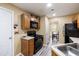 Practical kitchen design with wood cabinetry and black appliances offering an open view to the dining area at 4424 English Loop, Stonecrest, GA 30038
