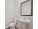 Charming half bathroom featuring a pedestal sink, framed mirror, and modern fixtures at 826 Bentley Dr, Fairburn, GA 30213