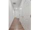 Bright hallway featuring wood flooring and neutral walls with white doors at 826 Bentley Dr, Fairburn, GA 30213