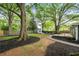 Expansive backyard with mature trees, a wooden deck, storage shed, and pathways perfect for relaxing outdoors at 957 Sharon Se Cir, Smyrna, GA 30080