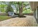Spacious backyard featuring a large deck, mature tree, and cozy fire pit area with a shed at 957 Sharon Se Cir, Smyrna, GA 30080