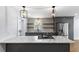 Open kitchen with gray cabinets, marble countertops, stainless appliances, and modern lighting at 957 Sharon Se Cir, Smyrna, GA 30080