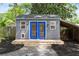 Backyard shed with charming blue doors and a small covered porch perfect for storage at 957 Sharon Se Cir, Smyrna, GA 30080