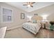 Cozy bedroom featuring neutral walls, and a plush patterned bed with ample natural light from the window at 6245 Hampton Golf Club Dr, Cumming, GA 30041
