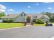 Inviting exterior view of building with manicured lawn, lush landscaping, and golf cart at 6245 Hampton Golf Club Dr, Cumming, GA 30041