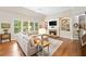 Bright living room features a stone fireplace, built-in shelving, and hardwood floors at 6245 Hampton Golf Club Dr, Cumming, GA 30041