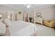 This spacious bedroom features a four-poster bed, hardwood floors, a sitting area, and an ensuite bathroom at 6245 Hampton Golf Club Dr, Cumming, GA 30041