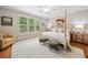 Bright main bedroom featuring a four-poster bed, large windows, and neutral walls at 6245 Hampton Golf Club Dr, Cumming, GA 30041