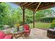 Charming stone patio with wicker furniture, surrounded by lush greenery and trees at 6245 Hampton Golf Club Dr, Cumming, GA 30041