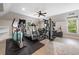 This is a workout room with modern exercise equipment and natural light from the window at 6245 Hampton Golf Club Dr, Cumming, GA 30041