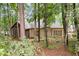 Backyard of a tan home with screened in porch, surrounded by lush green forest at 120 Bent Creek Dr, Woodstock, GA 30189