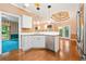 Well-lit kitchen featuring white cabinets, stainless steel appliances, and beautiful hardwood flooring at 120 Bent Creek Dr, Woodstock, GA 30189