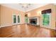 Bright living room featuring hardwood floors, stone fireplace, and double French doors at 120 Bent Creek Dr, Woodstock, GA 30189
