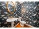Stylish powder room with floral wallpaper, pedestal sink, ornate gold mirror, and wood floors at 120 Bent Creek Dr, Woodstock, GA 30189