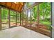 Enclosed screened porch with tiled floor and wooded backyard views at 120 Bent Creek Dr, Woodstock, GA 30189