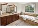 Bright bathroom showcasing a dual sink vanity, a soaking tub, and a large window at 2059 Howell Mill Nw Rd, Atlanta, GA 30318