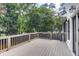 Exterior deck with light-gray painted wood planks and railing with green tree background at 2059 Howell Mill Nw Rd, Atlanta, GA 30318