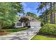 Charming single-story home with a manicured lawn, a two-car garage, and mature trees at 2059 Howell Mill Nw Rd, Atlanta, GA 30318