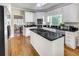 Spacious kitchen featuring white cabinets, black countertops, stainless steel appliances, and center island cooktop at 2059 Howell Mill Nw Rd, Atlanta, GA 30318