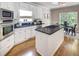 Well-appointed kitchen with white cabinetry, black countertops, stainless appliances, and a center island at 2059 Howell Mill Nw Rd, Atlanta, GA 30318