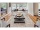 Bright living room features a decorative rug, tufted ottoman, and a white sofa near backyard access at 2059 Howell Mill Nw Rd, Atlanta, GA 30318