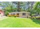 Charming single-story house with a well-maintained lawn and lush green landscaping enhancing its curb appeal at 2702 Rollingwood Se Ln, Atlanta, GA 30316