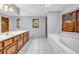 Bathroom with a white countertop, wooden cabinets, white tile flooring and a large tub at 362 Clyde Ct, Mcdonough, GA 30252