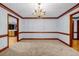 Dining space with neutral carpet and wood trim leading to kitchen, perfect for gatherings at 362 Clyde Ct, Mcdonough, GA 30252