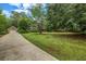 Home exterior featuring a long driveway leading to a detached garage and lush green lawn at 362 Clyde Ct, Mcdonough, GA 30252