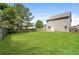 Expansive backyard features lush green lawn, mature trees, and a wood fence, perfect for outdoor activities at 40 Oakwood Dr, Covington, GA 30016