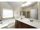 Bright bathroom features a double vanity, bathtub, and separate glass-enclosed shower at 40 Oakwood Dr, Covington, GA 30016