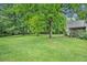 Green and spacious backyard featuring tall, mature shade trees and lush green grass at 1907 S Van Wert Rd, Villa Rica, GA 30180