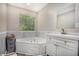 Bathroom featuring soaking tub, white vanity, and a large window at 1907 S Van Wert Rd, Villa Rica, GA 30180