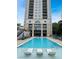 Outdoor swimming pool with lounge chairs and views of the surrounding building and sky at 3040 Peachtree Nw Rd # 1501, Atlanta, GA 30305