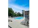 Resort-style pool area features lounge chairs, tables with umbrellas, and mature trees for shade at 3040 Peachtree Nw Rd # 1501, Atlanta, GA 30305